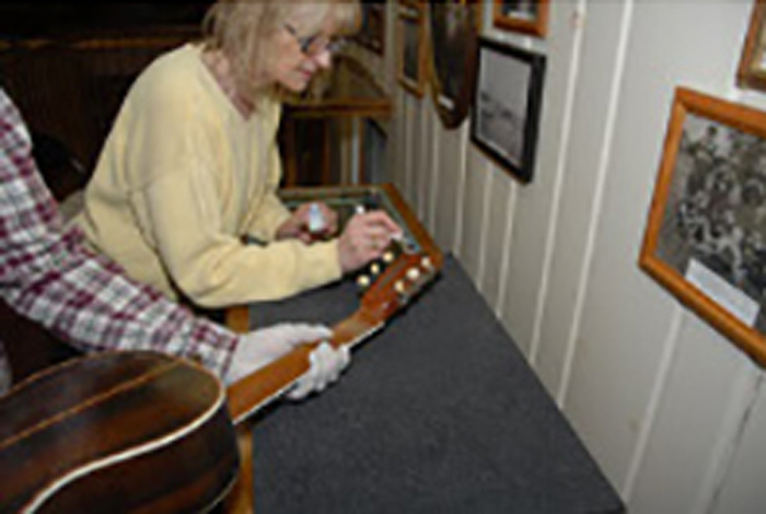 Two people are cataloging a guitar.
