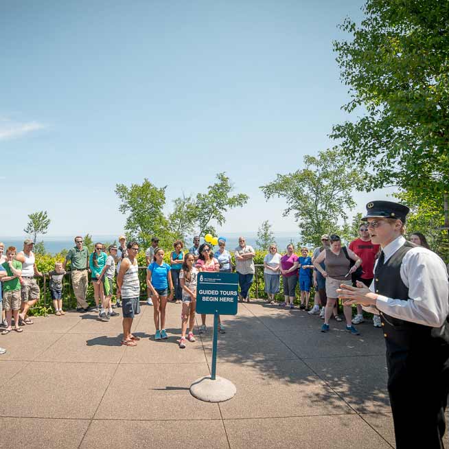 Tour guide dressed in lighthouse keeper uniform addressing a large group