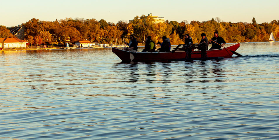 Six people in a canoe on a lake.