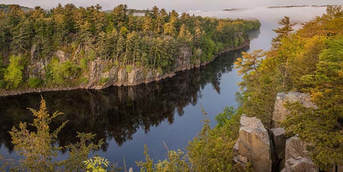 St. Croix river flowing through a valley of trees in early fall.