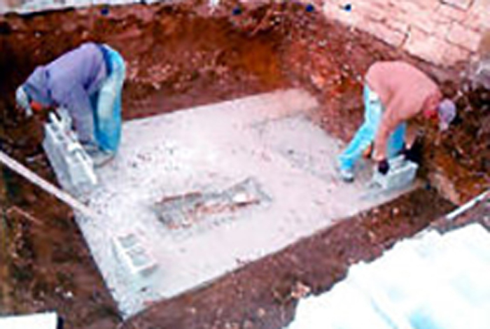 Two workers are building a foundation.