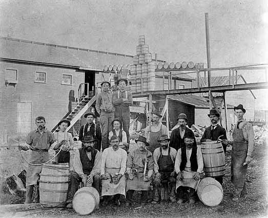 Photo of male workers posed with their barrels outside a cooperage, 1902.