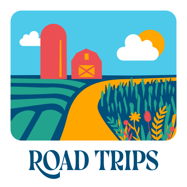 Road trips. View of a barn and silo in a farm field.