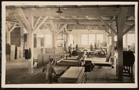 Sepia-toned photograph of laborers at work inside a lumber mill