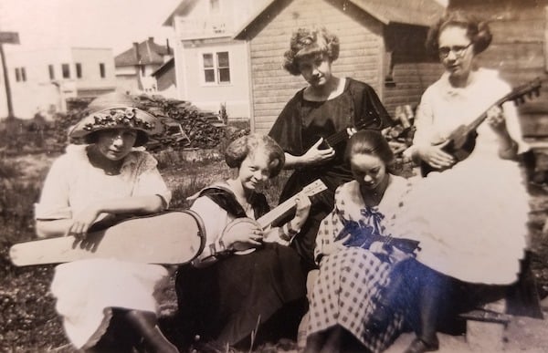 Five young women playing insturments outside