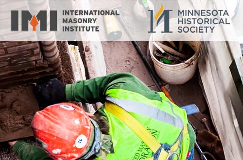 Photo looking down at a brick layer working with mortar on a brick wall