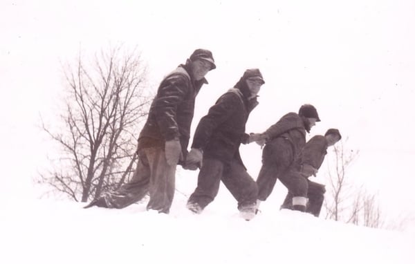 Image is of four men trekking through some deep snow, the photo was labeled CCC (Civilian Conservation Corps) ca.1930s