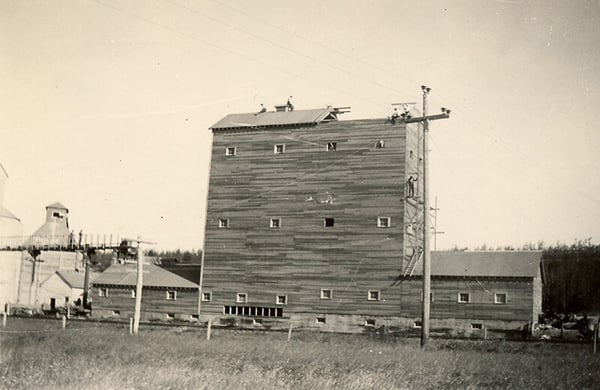 Black and white photo of a wooden silo being built