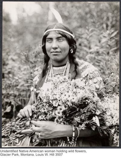Unidentified Native American woman holding wild flowers, Glacier Park, Montana. Louis W. Hill 3507