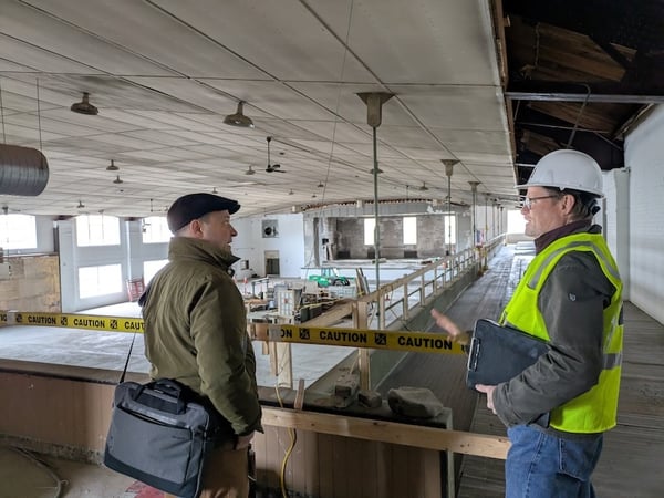 Man talking to construction worker with Auditorium in background