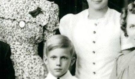 cropped photo showing boy with hints of other family members around him
