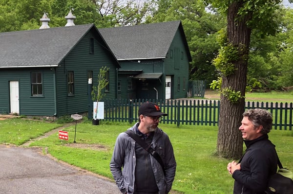 Two people in foreground talking in background is the Linden Hill Carriage House