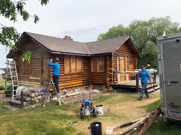 Two construction workers working on the Hackensack Conservation Building, a log building