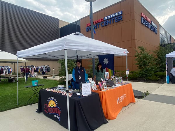 Two staff in the Minnesota Historical Society and Minnesota Discovery Center booth at the Range Iron Pride Festival