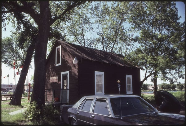 Oscar Hokka Log House with a 1980 Buick Regal parked next to it.  Virginia Area Historical Society-July 1984