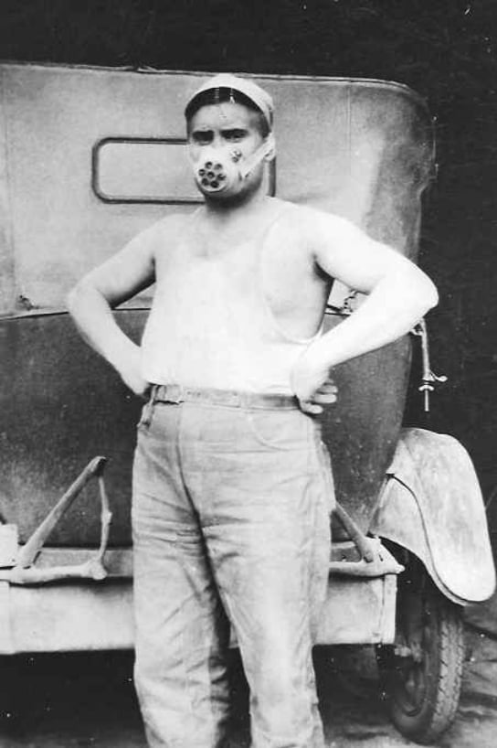 Ralph Tangjerd wearing mask as he unloaded a carload of cement for paving Highway 2. About 1928