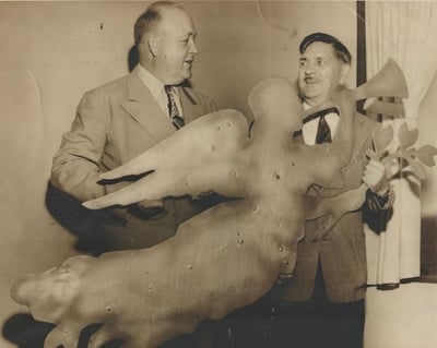 Two men holding the Angel Gabriel Weathervane ca. 1940s