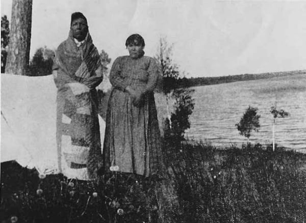 Native American couple camping by Lake Lomond