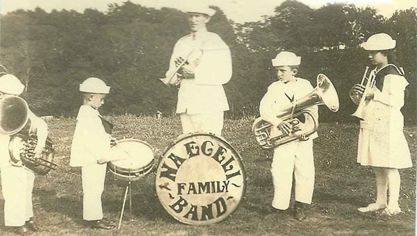 Father and four young children in salior suits hold band instruments - Drum says, Naegeli Family Band