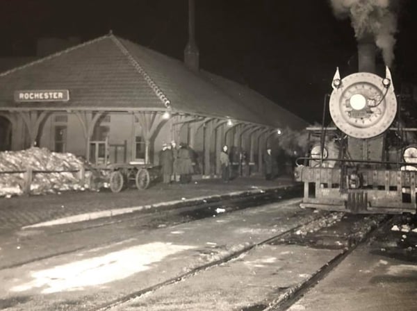 Black and White photo of Rochester Depot with Steam locomotive next to it