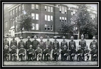 A historical group photo of uniformed National Guard in front of Duluth Armory