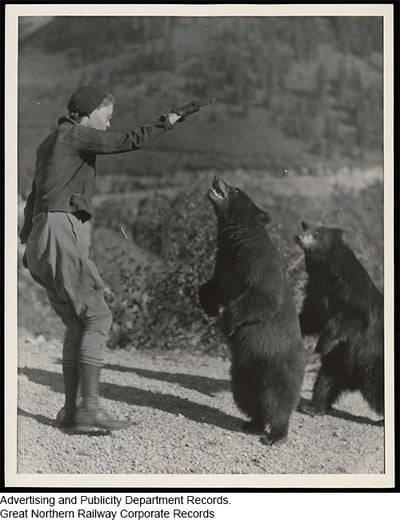Woman holding hand above two bears
