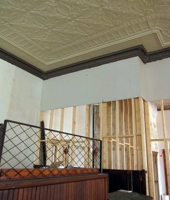 tin ceiling with wood wall framing in background
