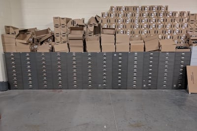 A storage area with 12 microfilm cabinets beneath a chaotic pile of brown cardboard boxes
