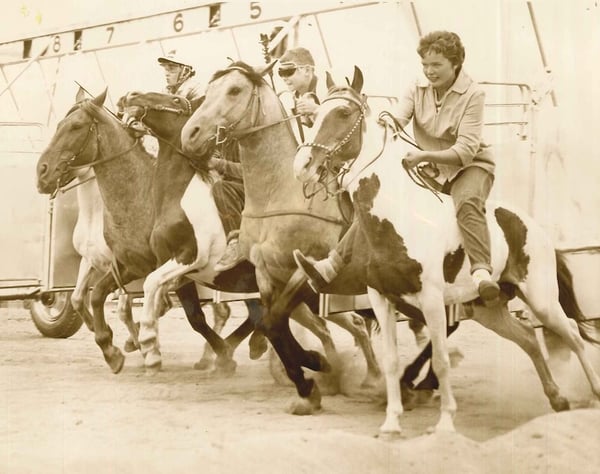 Horse racing at the fair. The person in the middle has some stylish goggles