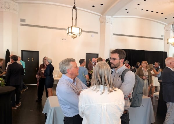 John Crippen talking with other guests at theYoung Quinlan 100th Anniversary Celebration event