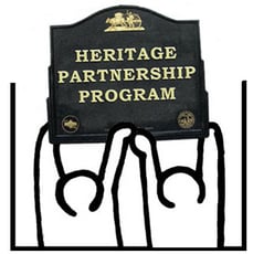 Grant of two people holding up historical marker saying Heritage Partnership Program