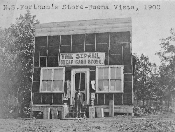 Black and White photo of commerial building covered with tar paper. Sign on building says, St. Paul Cheap Cash Store. A man is standing in front of store. Typed on the photo is N.S.Fortuns Store-Buena Vista, 1900