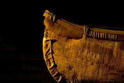Image of the bow of a birch bark canoe. Barely seen in bark are designs of stars and a moose