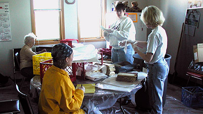 Four people working around a table with damaged documents
