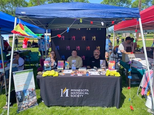 Three staff sitting at the table at Minnesota Historical Society booth