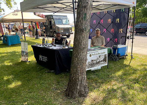 Booth with both Minnesota Historical Society and Pine City Area Historical Association tables and staff