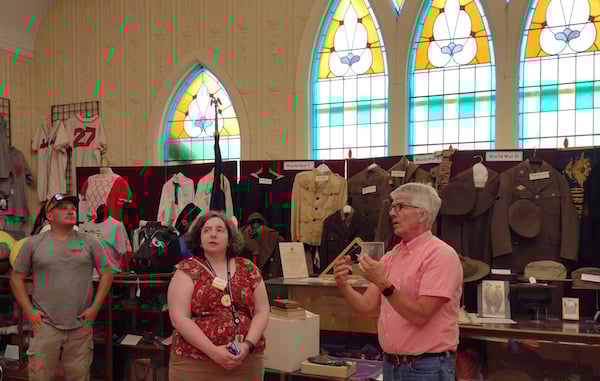 Two people talking in museum gallery with military uniforms behind them