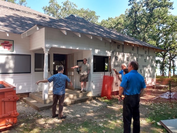 Five people talking outside the Oaks Lakeside Pavillion next to dumpster and construction fencing.jpg 
