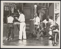 Black and white photograph of the exterior of Fisher’s Barber Shop splashed with red paint, c.1940s.