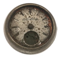 The face of round pocketwatch destroyed by fire sits against a white background.