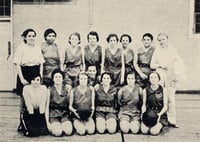 Women in athletic clothes kneel and stand in two rows of seven or eight each. 