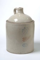 A cylindrical jug with a round top leading to a grooved spout and a handle.