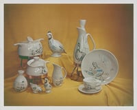 White ceramic items sit staged against a yellow cloth backdrop.