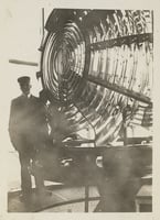 Black and white photograph of Franklin J. Covell by the Split Rock Lighthouse lens.
