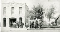 Black and white photograph of Cannon Falls firefighters posing in front of their headquarters.