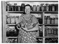 Woman with canned vegetables, part of Farm Security Administration program.