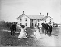 Black and white photograph of students performing a drill on the grounds of a Native American boarding school, c.1890s.