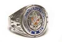 Color image of a Sterling silver Civilian Conservation Corps ring with CCC logo flanked by an eagle and shield on opposing ends. Logo is engraved with 3707/ and EAF. Worn by Fred Fretheim of Company 3707, Two Harbors, MN, ca. 1936–1937.