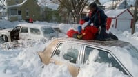 Color image of children playing on top of a car after the Halloween Blizzard, 1991. Photograph by Marlin Levison, Minneapolis Star Tribune.