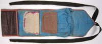 A soldier's housewife sewing kit made from a strip of leather with a twill-like finish and lined with silk.